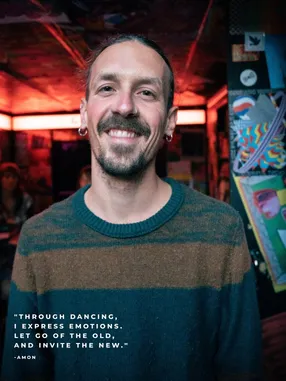 Portrait of an XD community member smiling in a striped sweater, with a personal quote